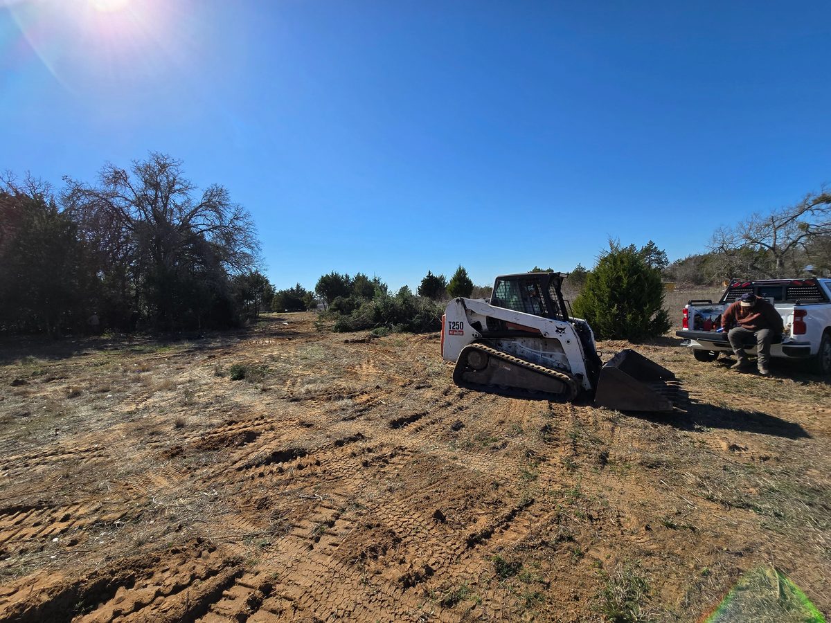 Track loader clearing a lot